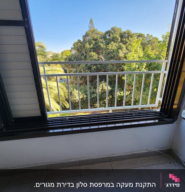 מסגרת חלון פתוחה עם נוף לעצים ירוקים
